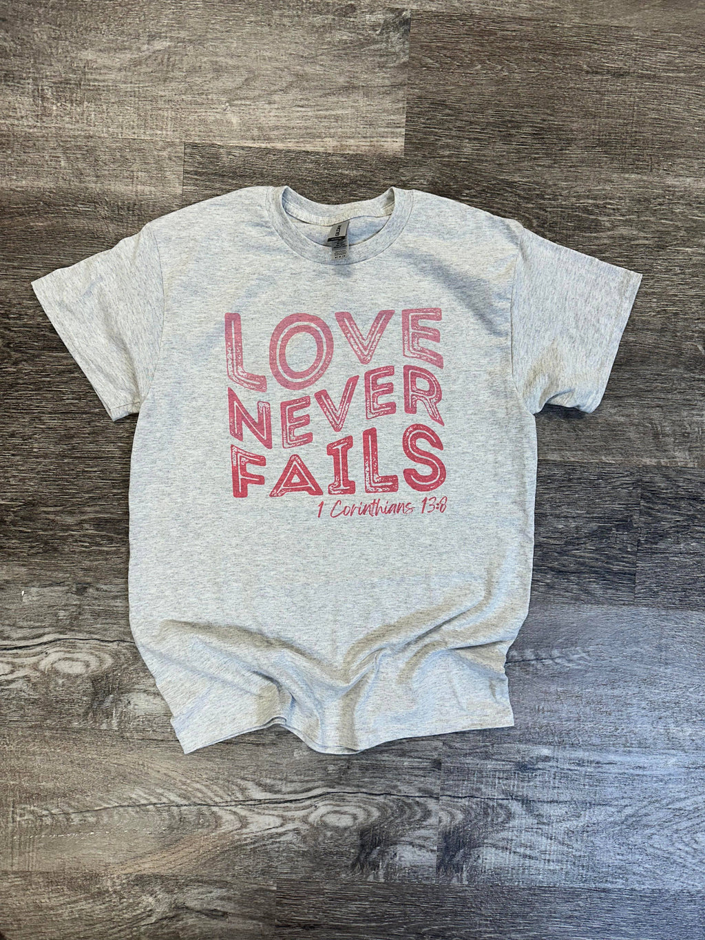 Love Never Fails - 1 Corinthians 13:8 - Ash Gray Tee